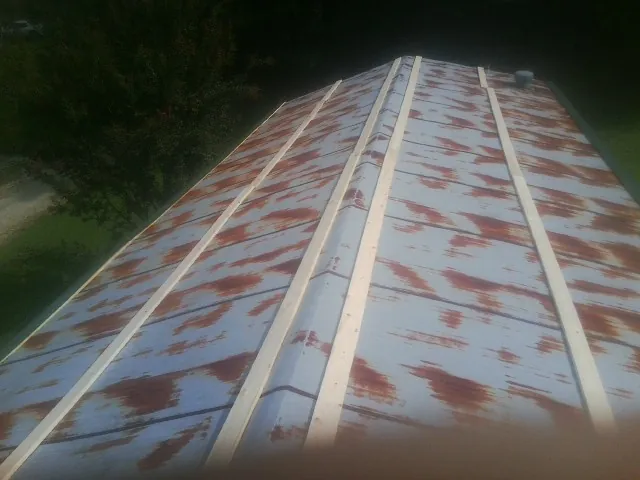 Rusted metal roof panels with new wood purlins before replacement — Storm Damage Roof Repair in Oldtown by Roofing Brothers