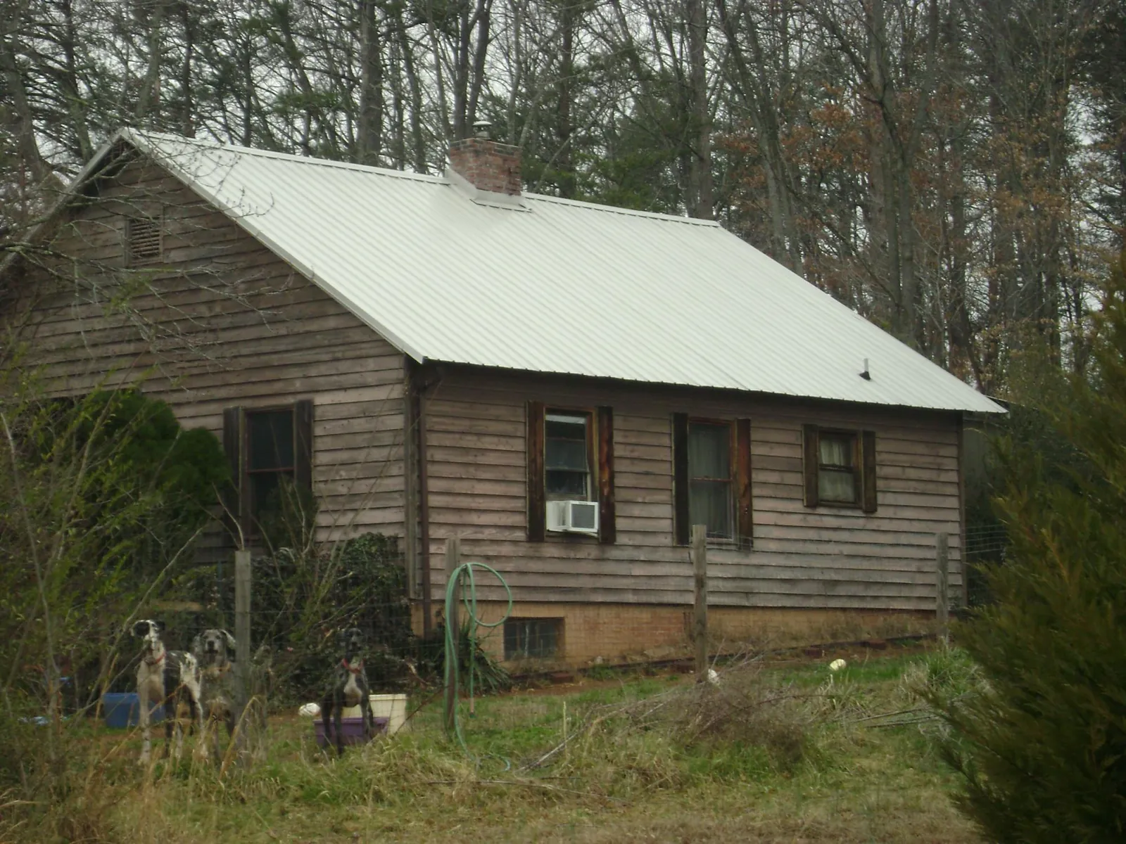 White metal roof on an old wood sided farmhouse, from a Metal Roof Installation job in Oldtown